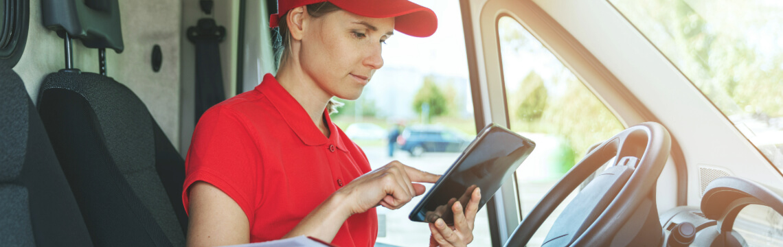 Deliverer sitting in van, preparing to deliver parcels.