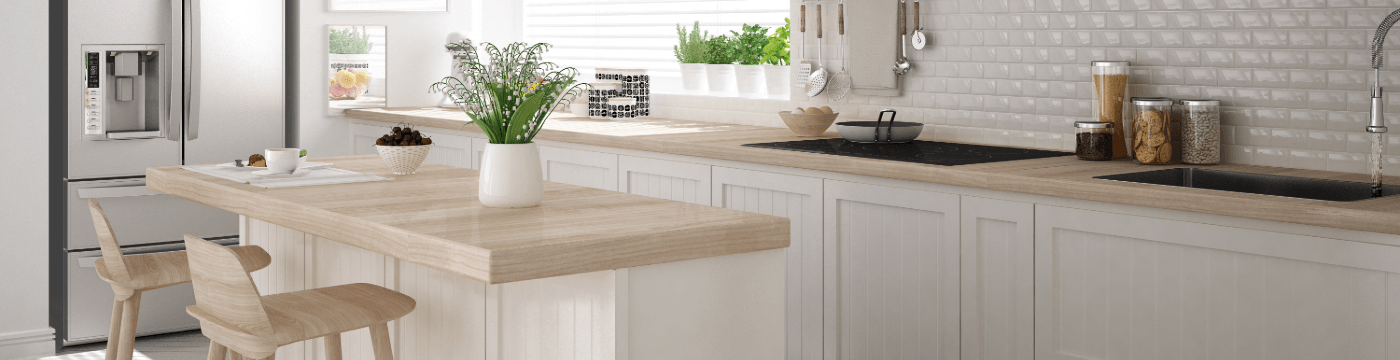 Bright empty clean kitchen with a refrigerator, island with two seats, and plants on the counters